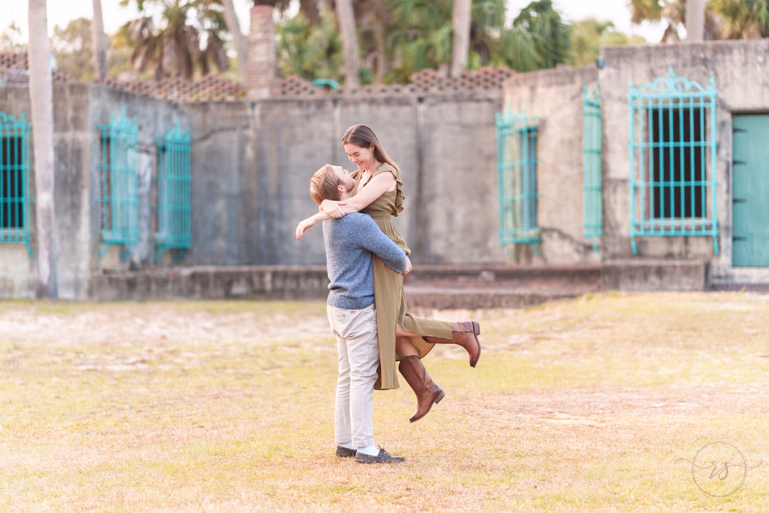 He lifts her up on the lawn in front of Atalaya Castle - Huntington Beach State Park