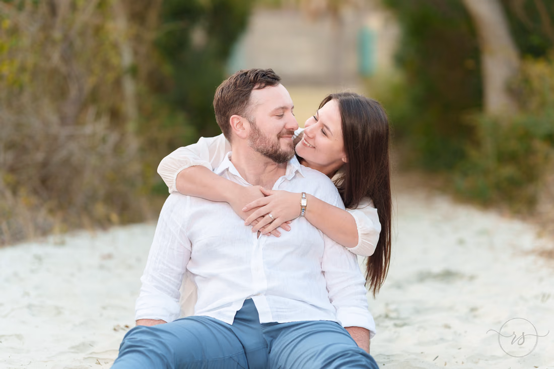 Couple hugging while sitting on the sandy beach path - Huntington Beach State Park