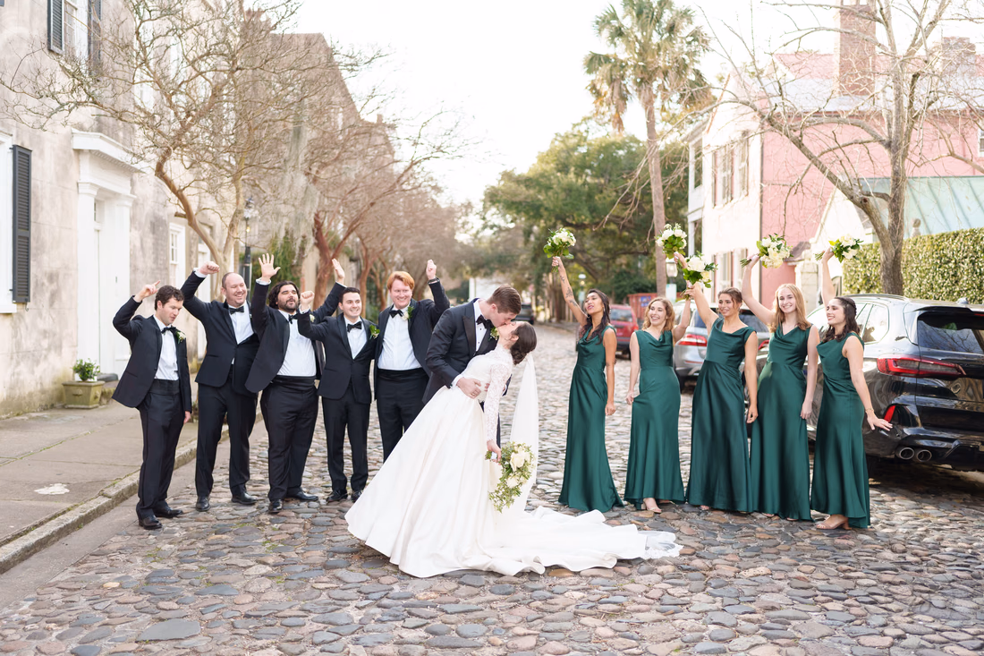 Bridal party cheering as the groom dips the bride on the cobblestones - Chalmers Street