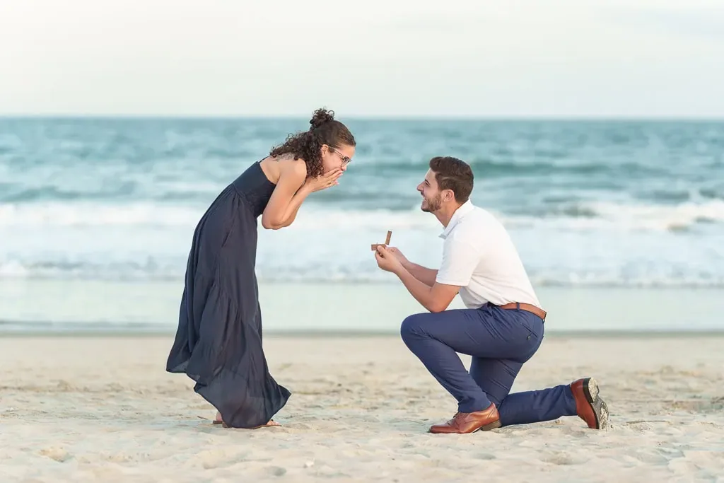 Surprise proposal on the beach as she covers her face, from Dante's session