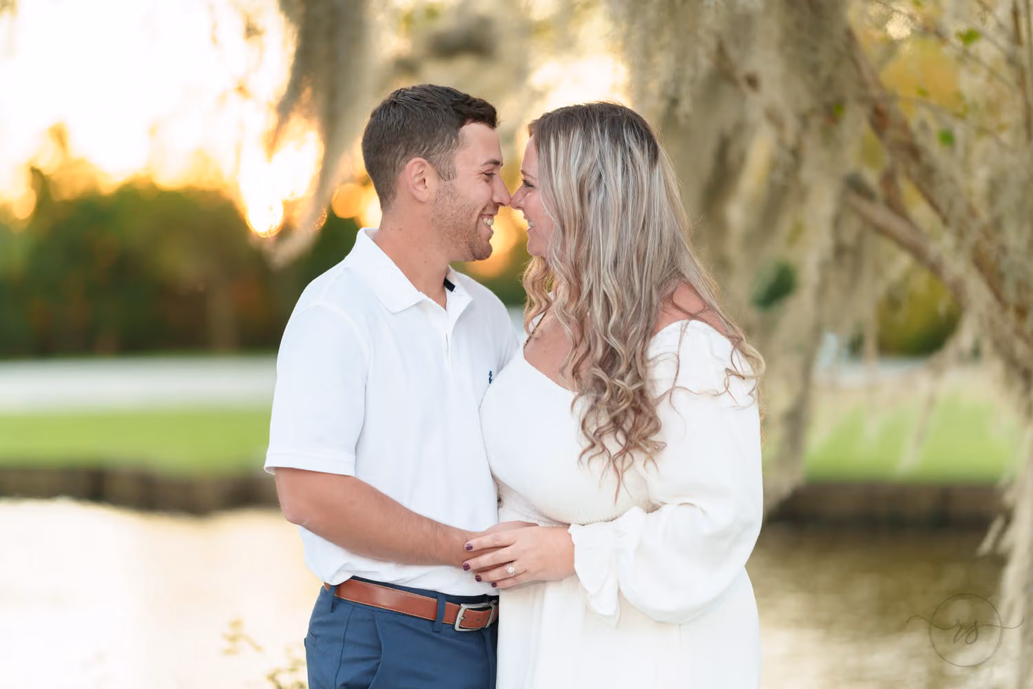 Couple touching noses in warm sunset light by the river under Spanish moss at the Conway Riverwalk