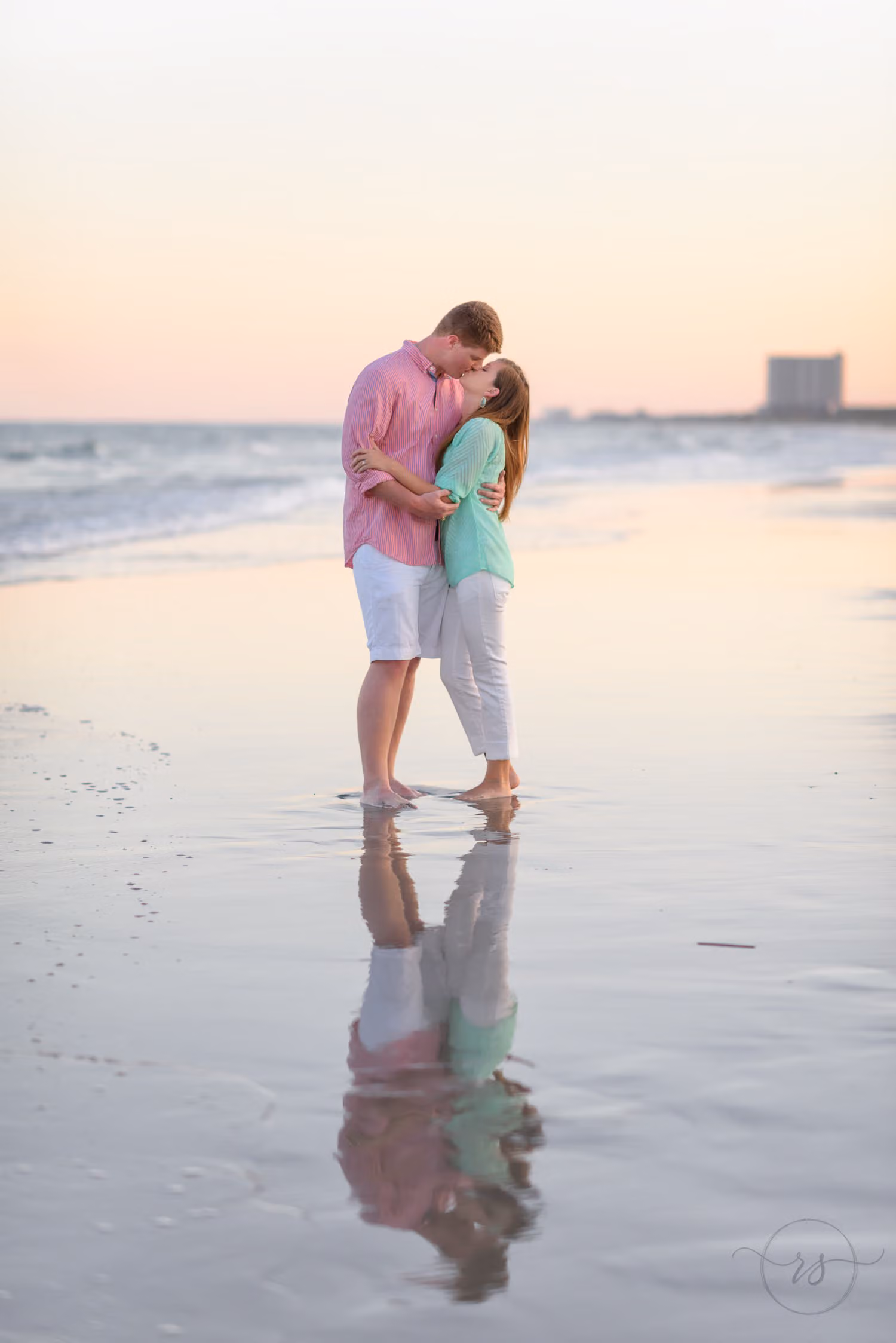 Couple hugging on wet sand at dusk with their reflection mirrored below them at Myrtle Beach State Park