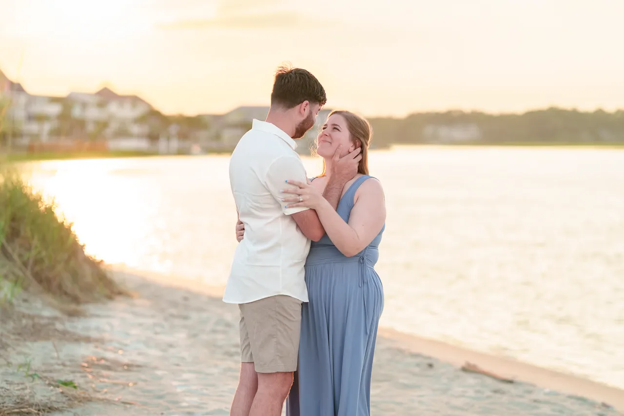 Zachery and his partner embracing on the beach in warm sunset light