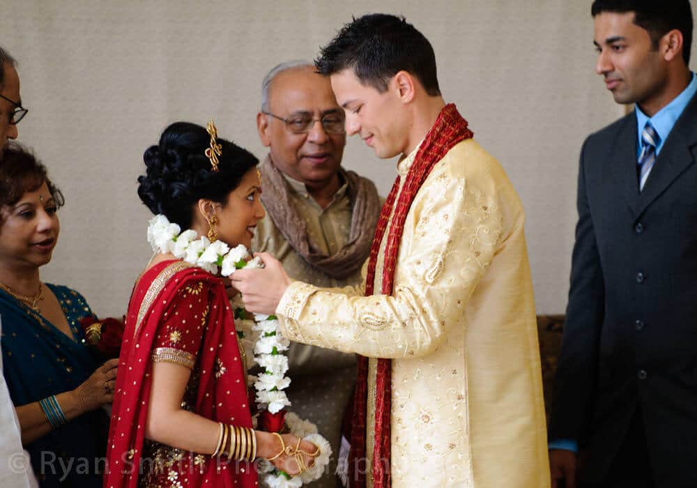 Groom putting flowers around neck of bride - Indian Wedding ceremony