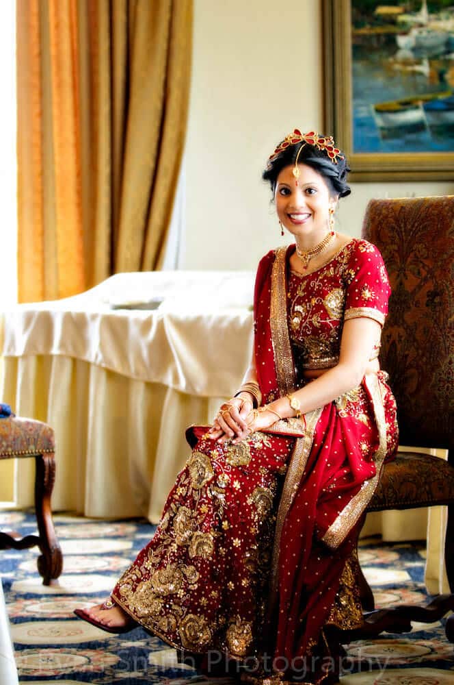 Indian bride sitting in chair by window light