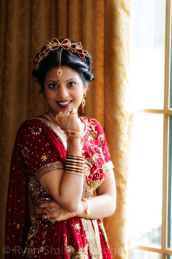 Indian bride with hand on chin in window light