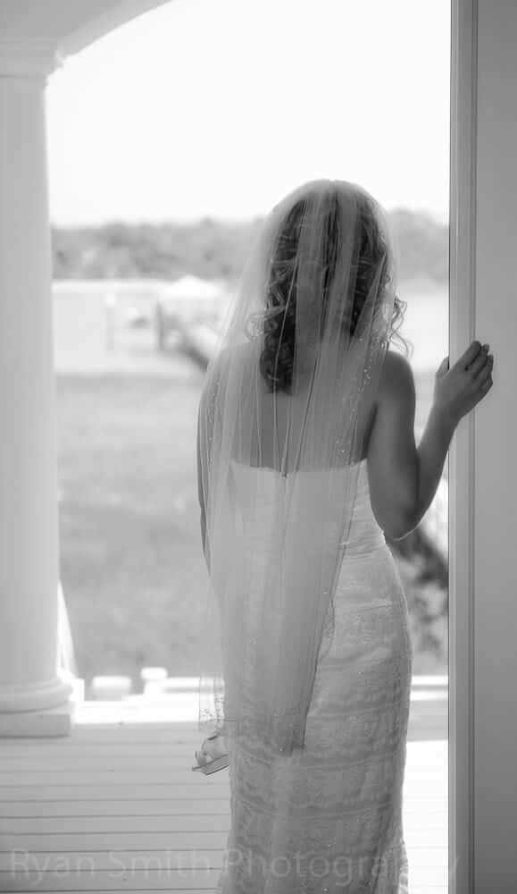Bride looking out of doorway, soft black and white, ocean isle beach
