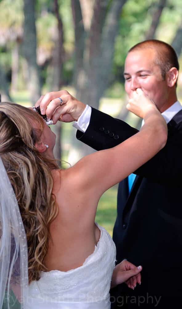Groom pushing cake into brides face, ocean isle beach