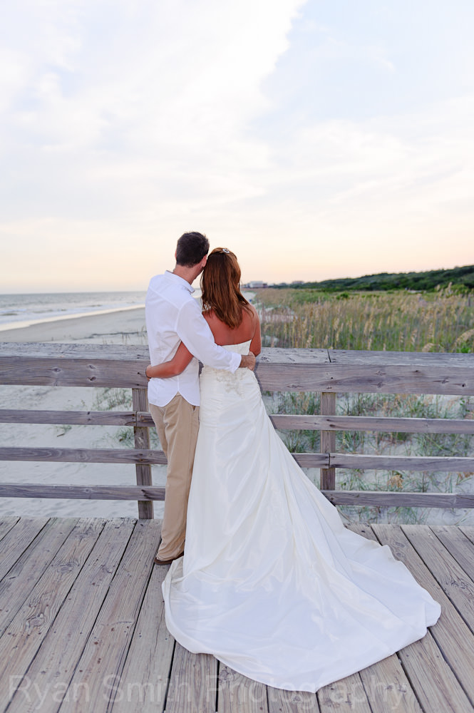 Bride and groom looking out over the dunes at the pier, State Park