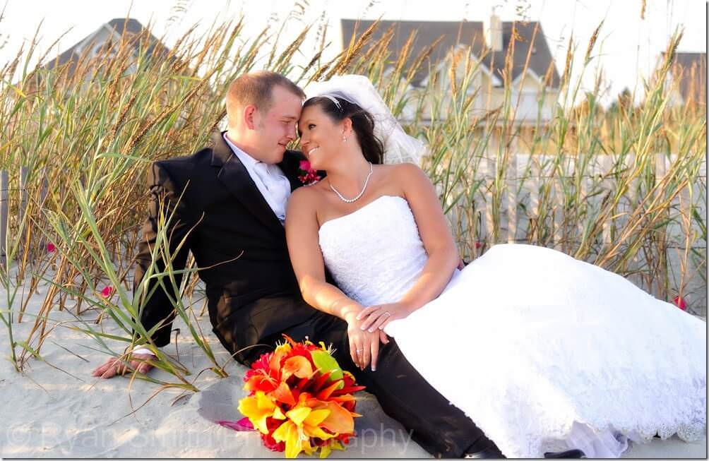 Similing at groom laying by seaoats, North Myrtle Beach