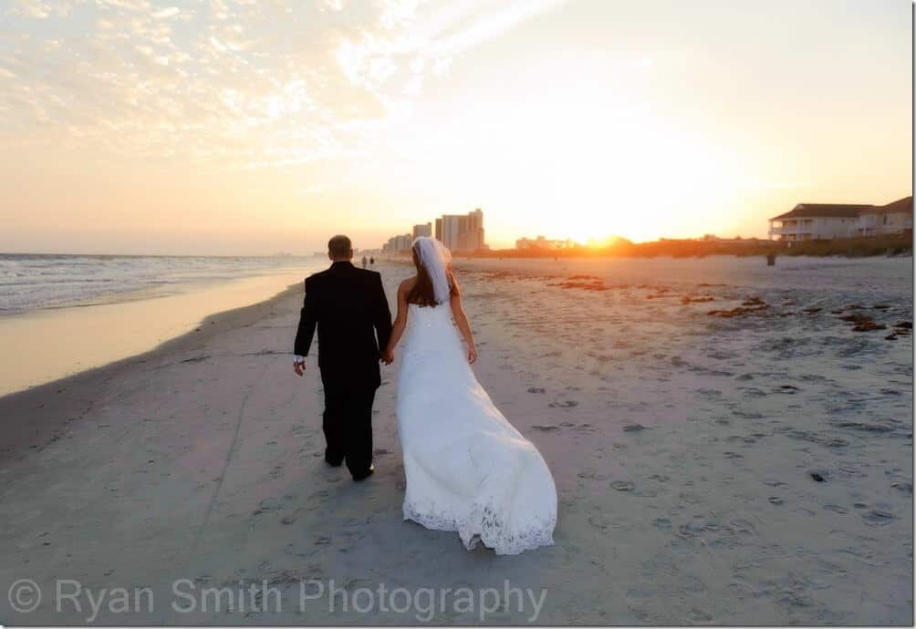 Bride and groom walking into sunset