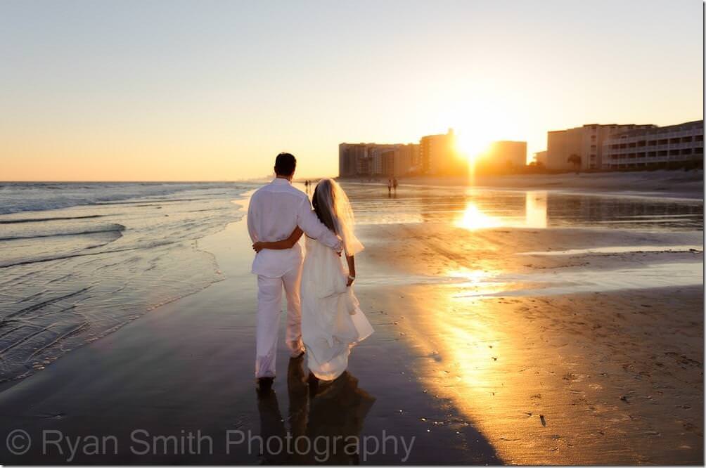 Bride and Groom walking together with sun behind hotel in Myrtle Beach