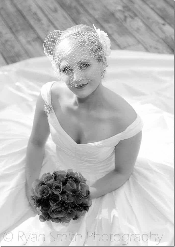 Bride sitting on dock looking up