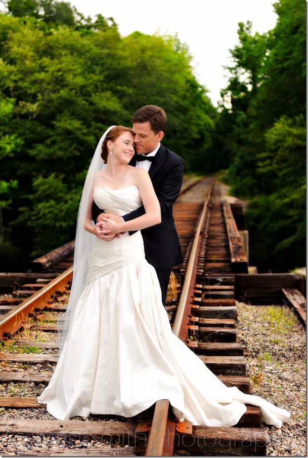 Bride and groom standing on railroad tracks - Conway River Walk
