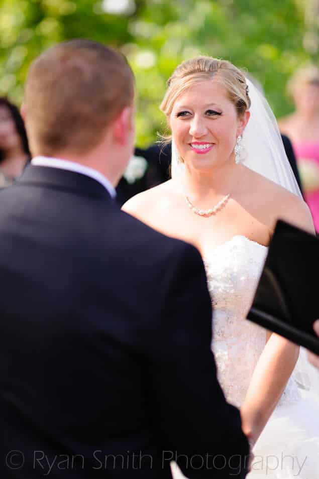 Bride smiling at groom during the ceremony - Conway River Walk
