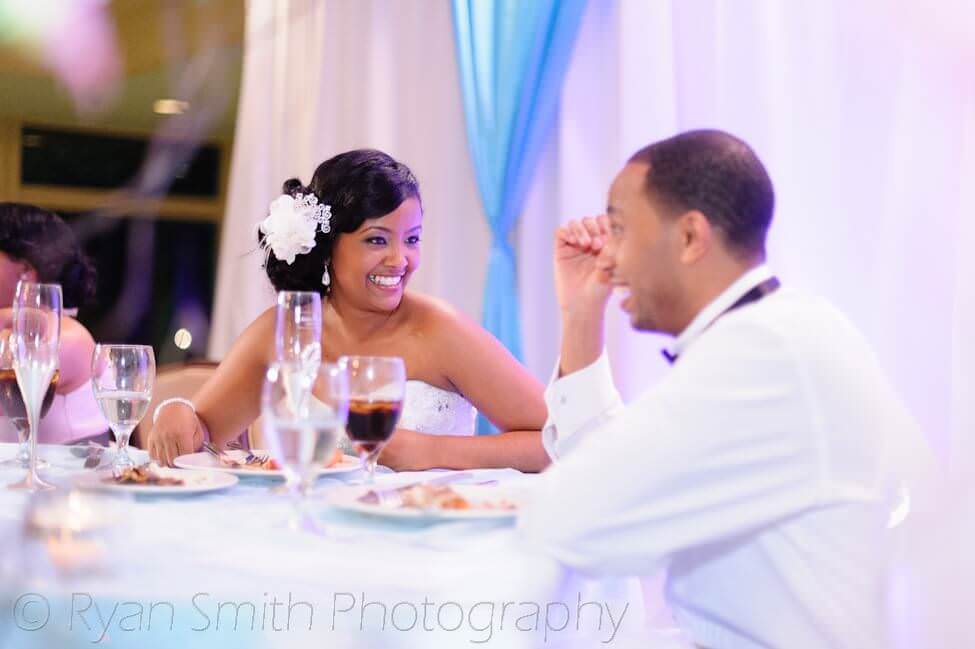 Bride smiling at groom at table