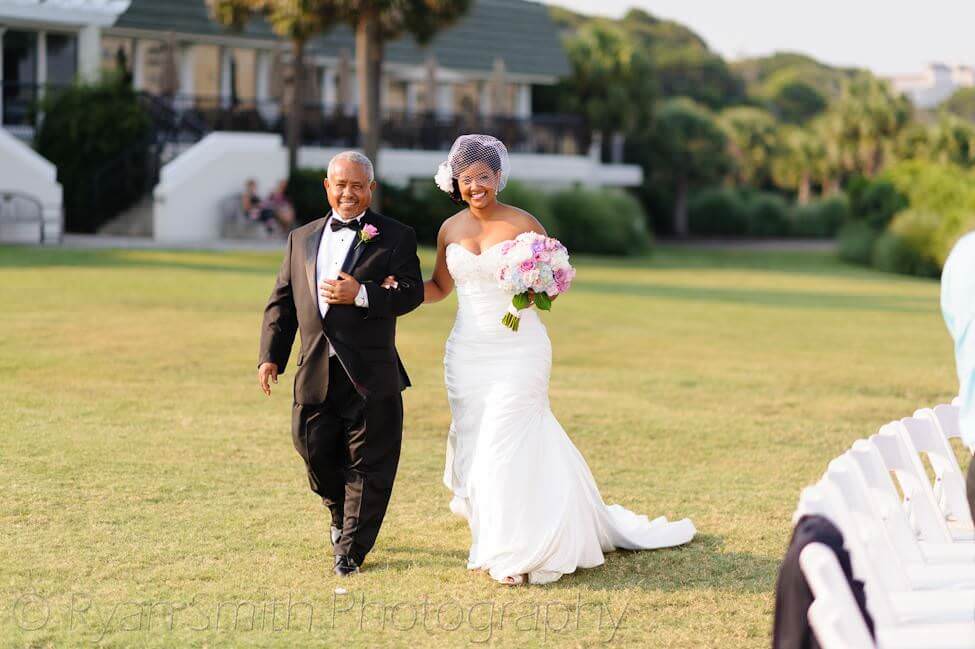 Bride walking towards ceremony with father