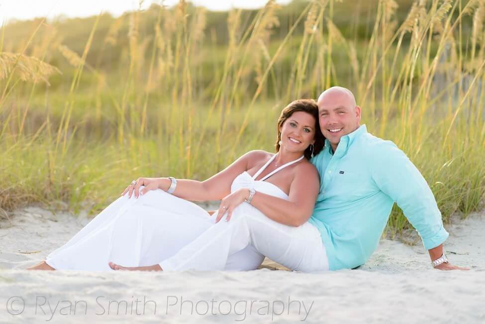 Engagement couple laying together in front of the sea oats - Myrtle Beach State Park