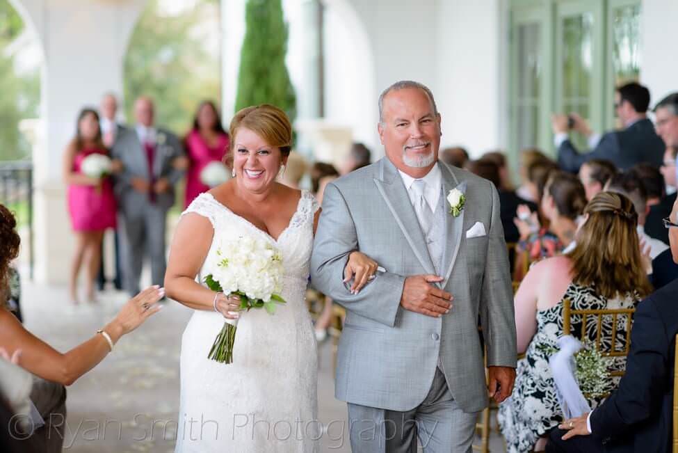 Bride and groom walking away from ceremony, they look very happy - Member's Club - Grande Dunes