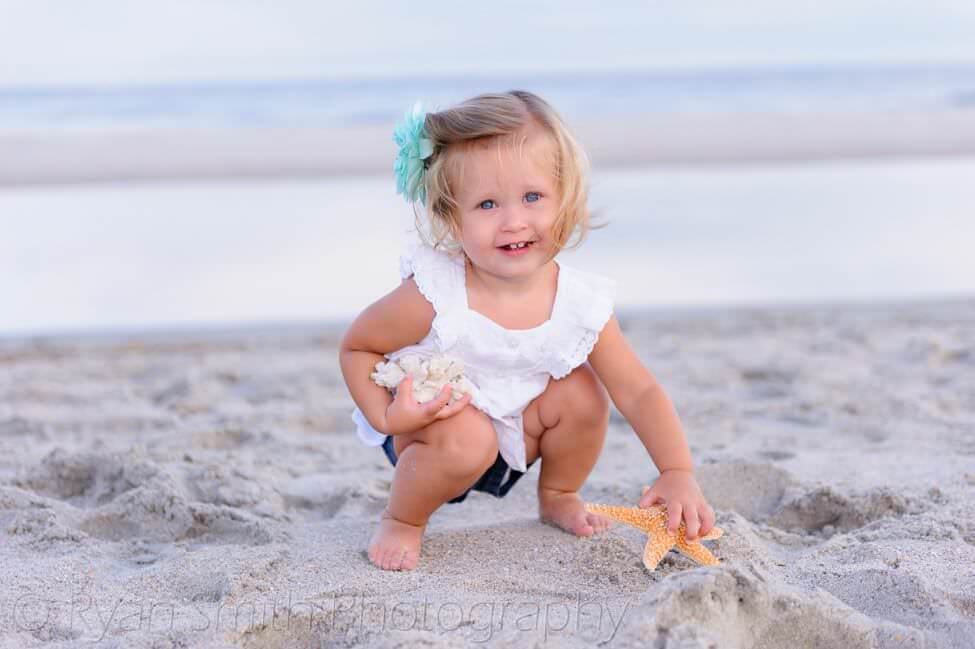Cute baby girl playing with shells