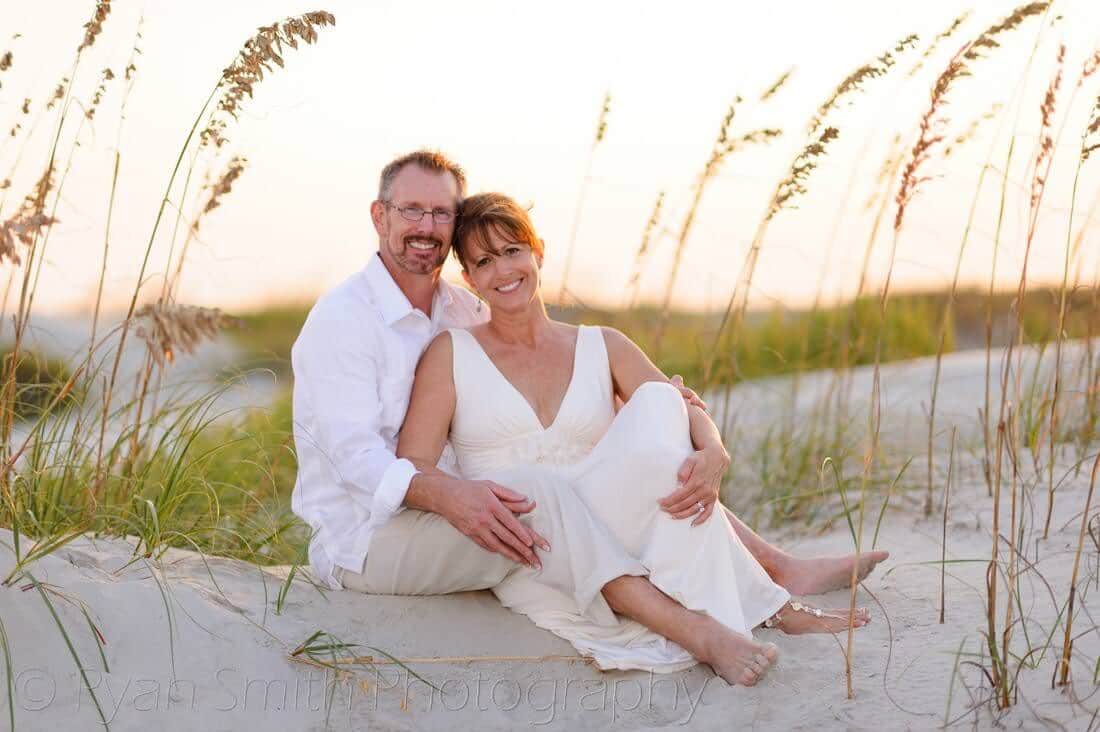 Couple sitting in the sea oats and the sunset - Holden Beach, NC