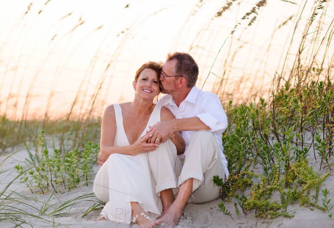 Couple sitting in the sea oats and the sunset - Holden Beach, NC