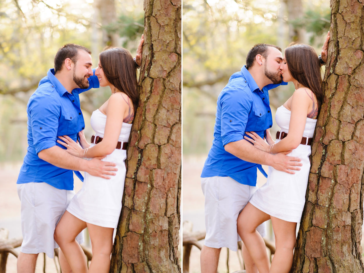 Engagement picture leaning girl against tree for a kiss