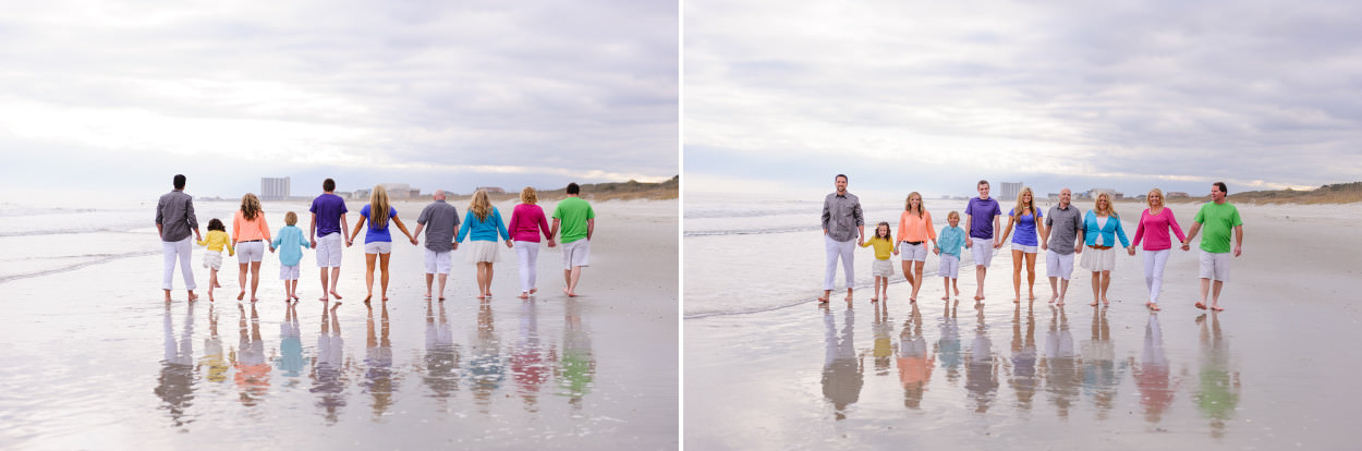 Large family walking down the beach with a reflection of them in the water