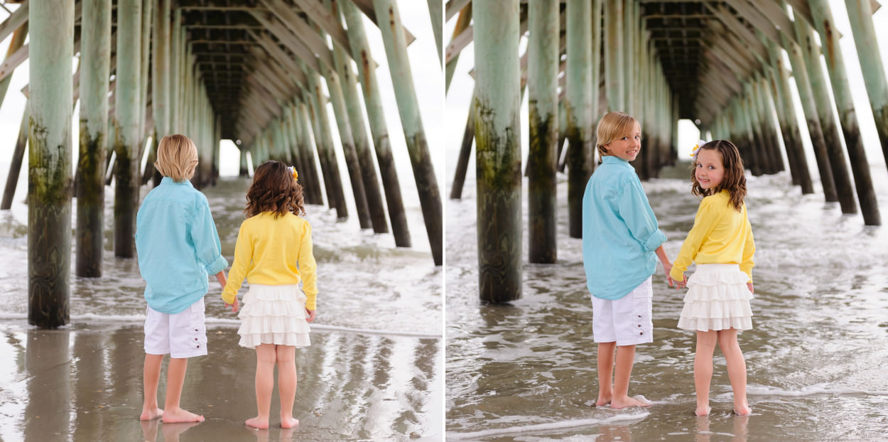 Brother and sister holding hands looking at the ocean