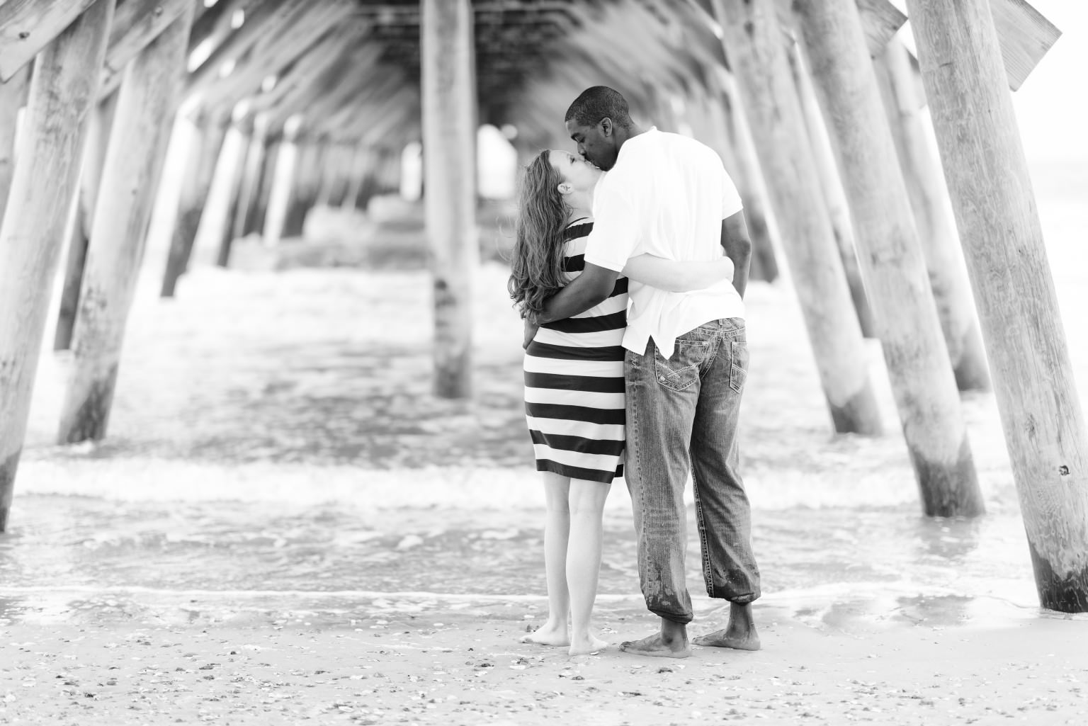 Black and white portrait of couple under the pier
