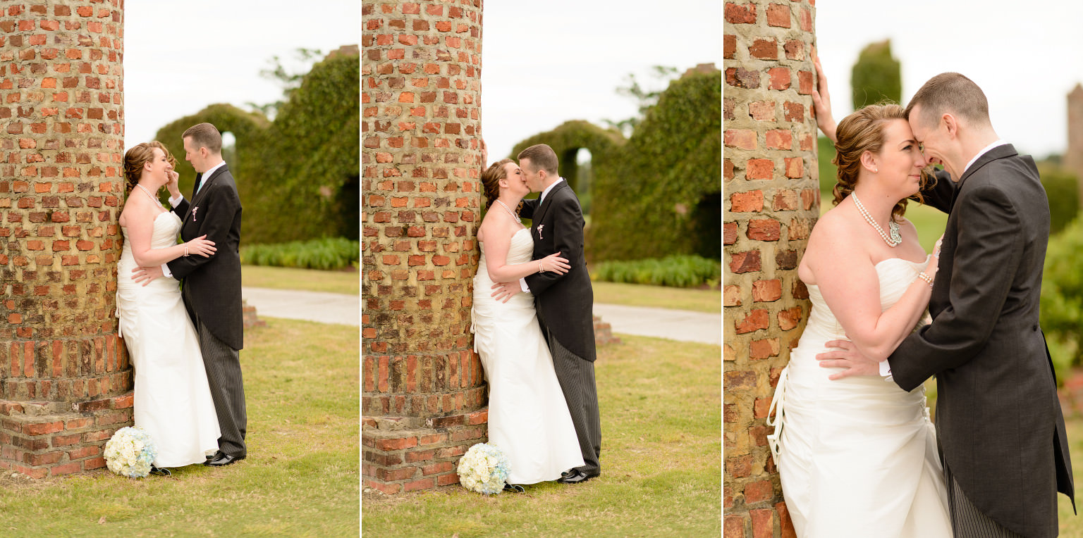 Bride and groom kissing against the recreated ruins on the Love Course