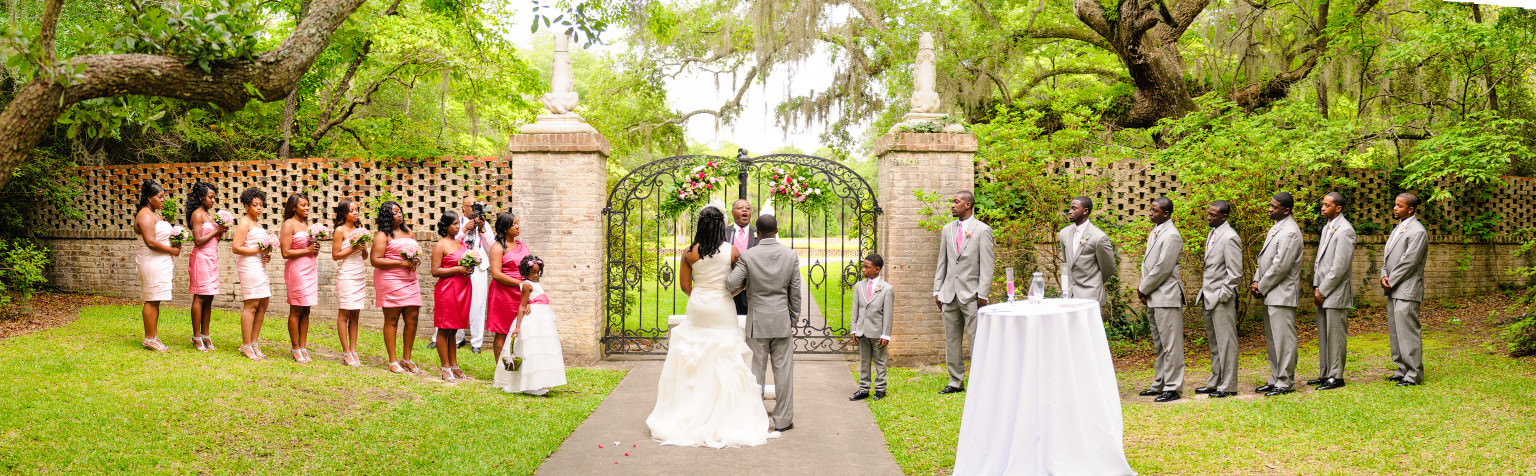 Panorama of wedding party in front of the Brookgreen Gardens Holiday Cottage Gates