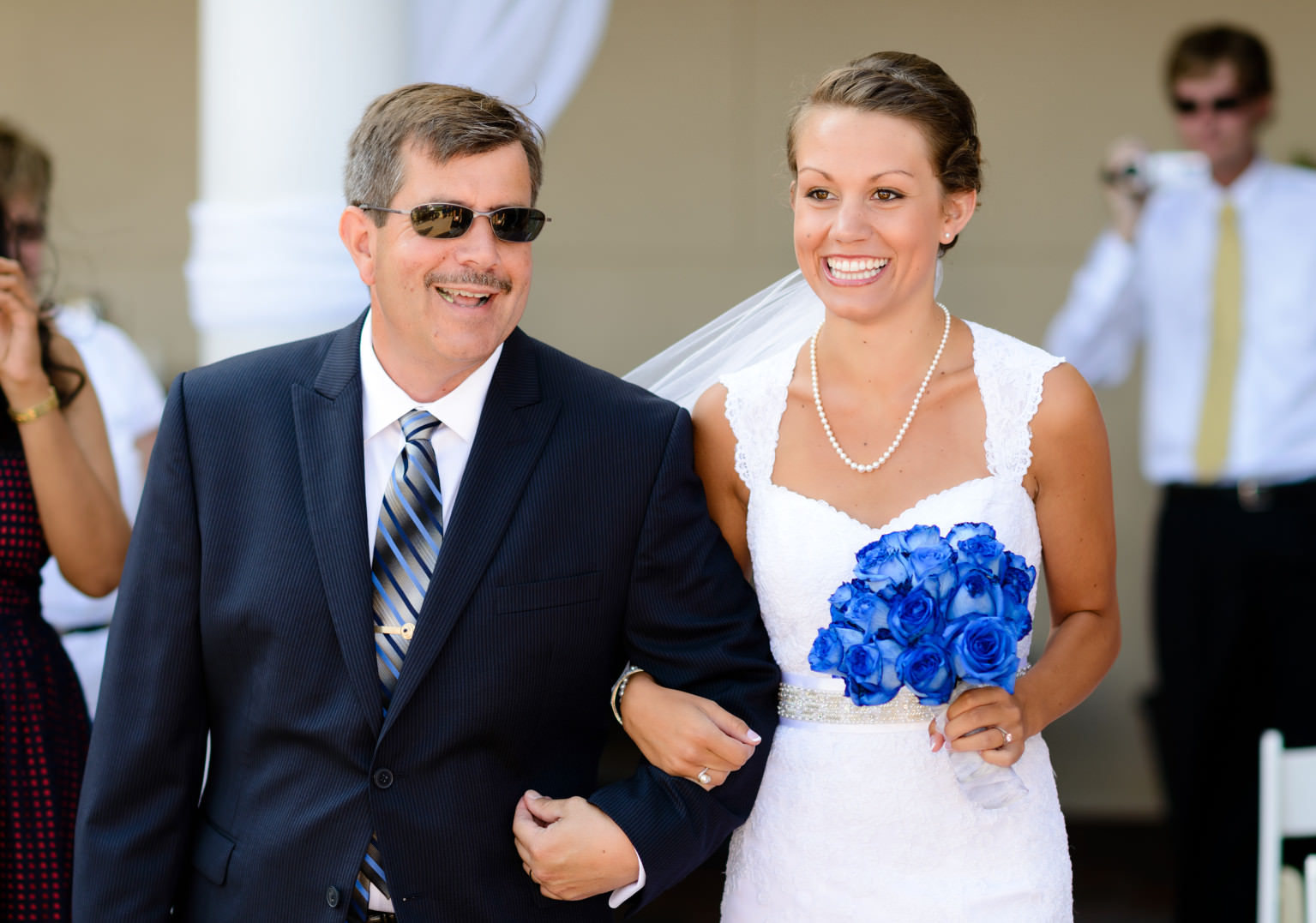 Bride looks very happy walking down isle with father