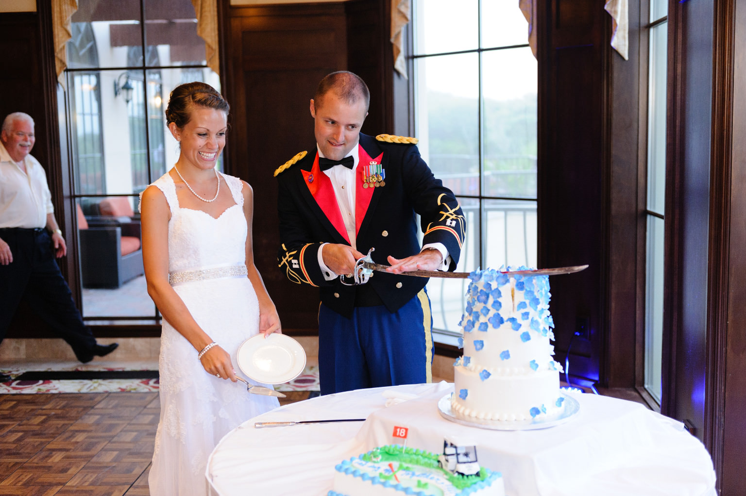 Cutting wedding cake with military saber