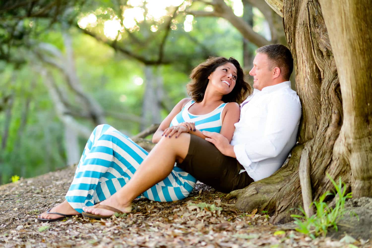 Beautiful engagement portrait girl looking up at guy backlit by sunset - Myrtle Beach State Park