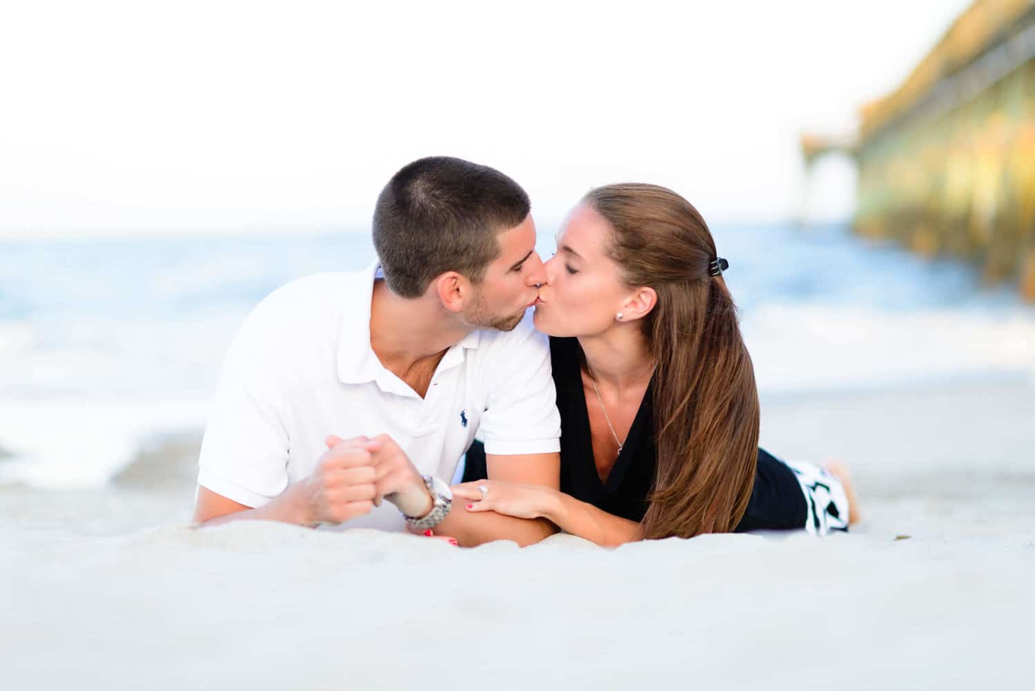 Couple laying in the sand kissing in front of the ocean - Myrtle Beach State Park