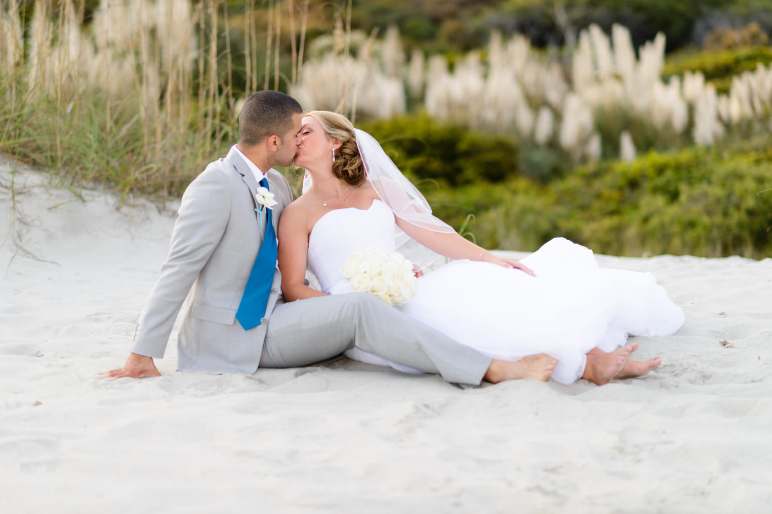 Couple kissing in front of the dunes at the Grande Dunes Ocean Club Myrtle Beach