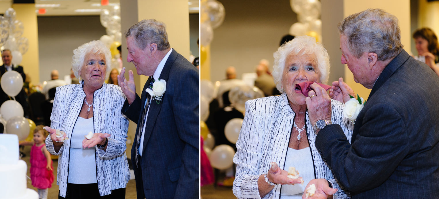Older couple feeding each other cake at anniversary party