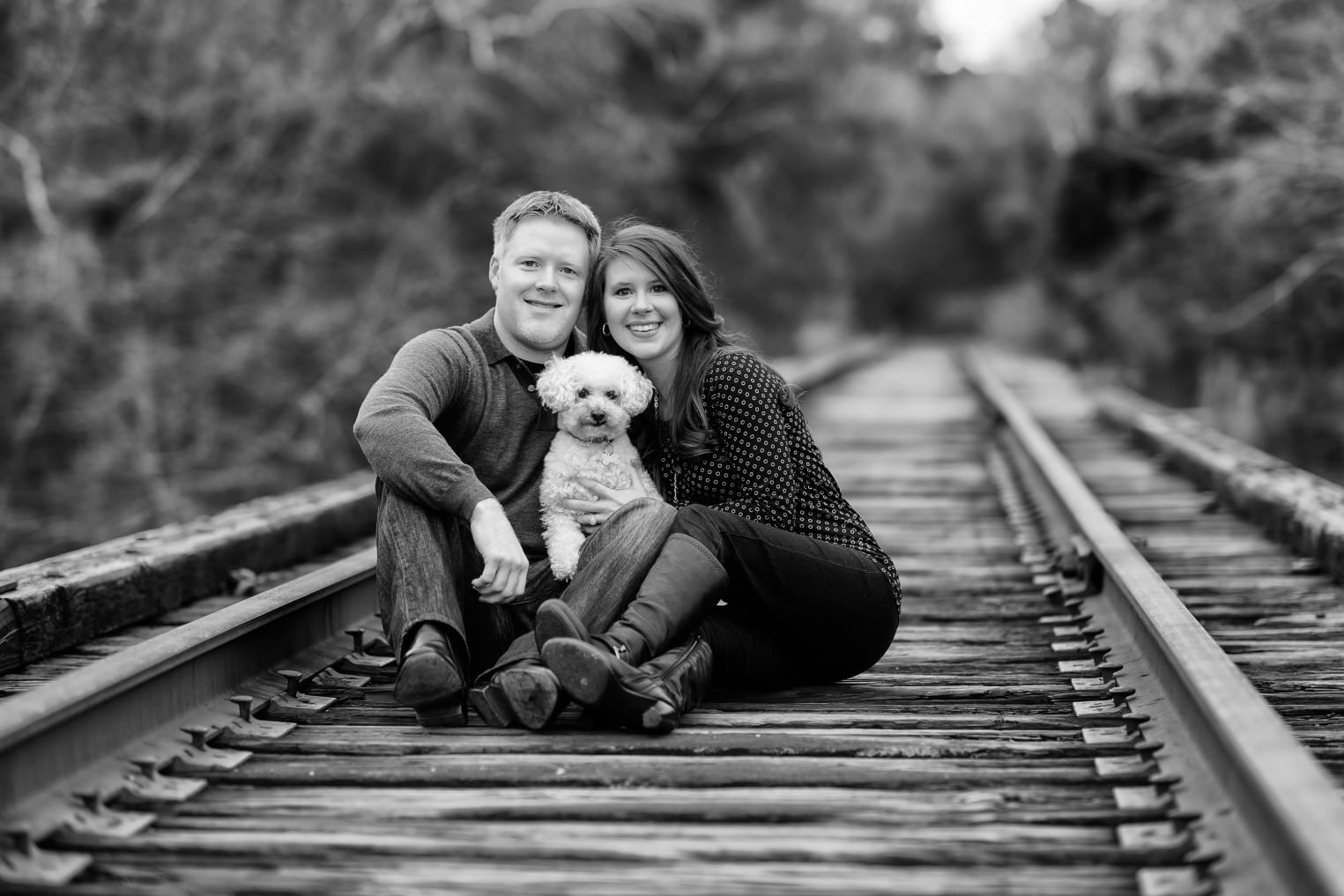 Engagement portrait with poodle sitting on the train tracks - Conway River Walk