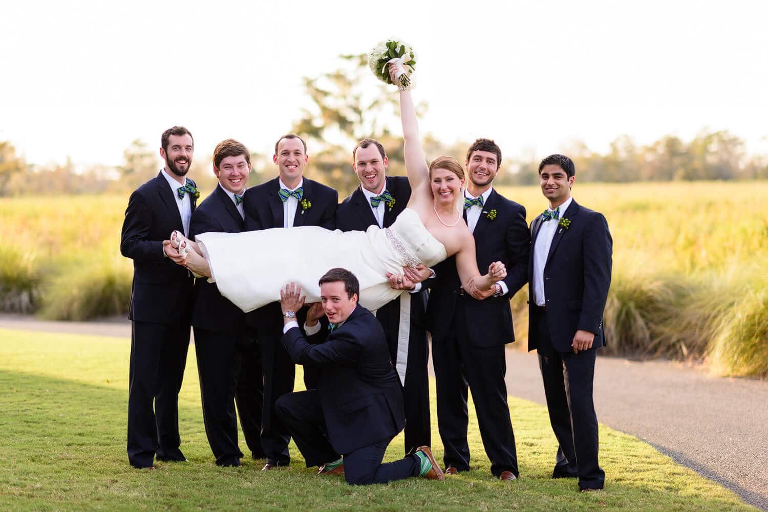 Groomsmen picking up the bride