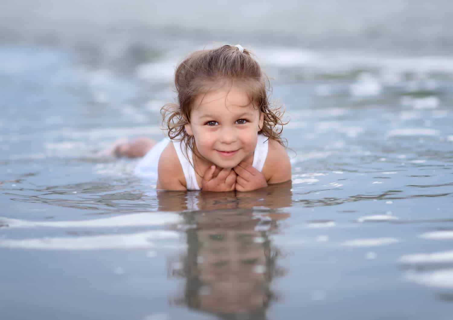 Little girl laying in the water