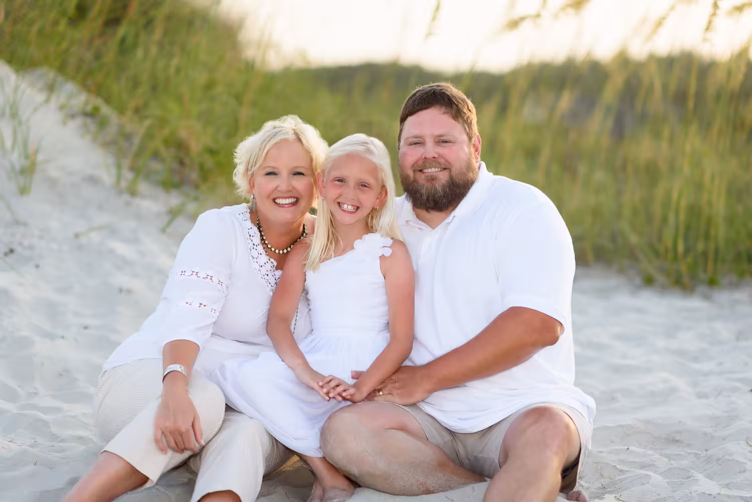 Cute family of three sitting on the beach together - Myrtle Beac