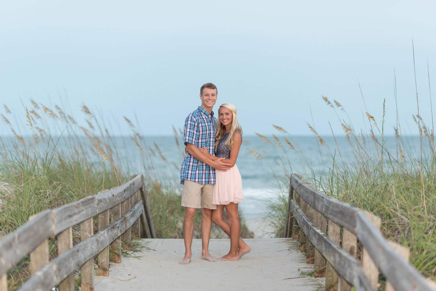 Couple on a beach walkway by the sea oats