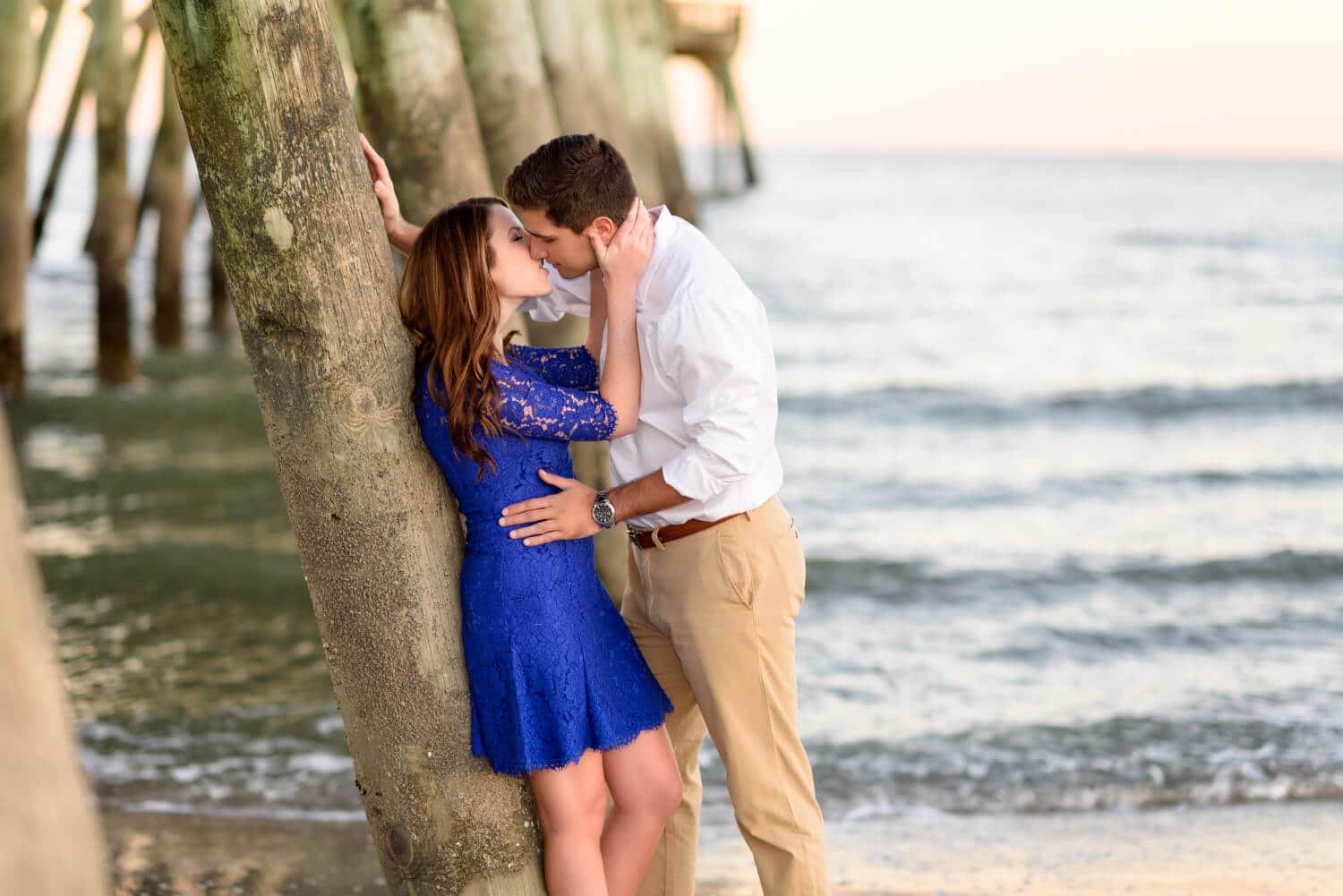 Couple about to kiss leaning against the pier at state park