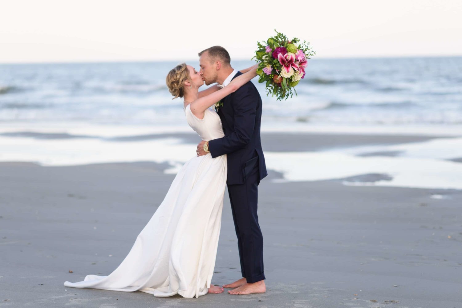 Bride with her arms around groom kissing -  Grande Dunes Ocean Club