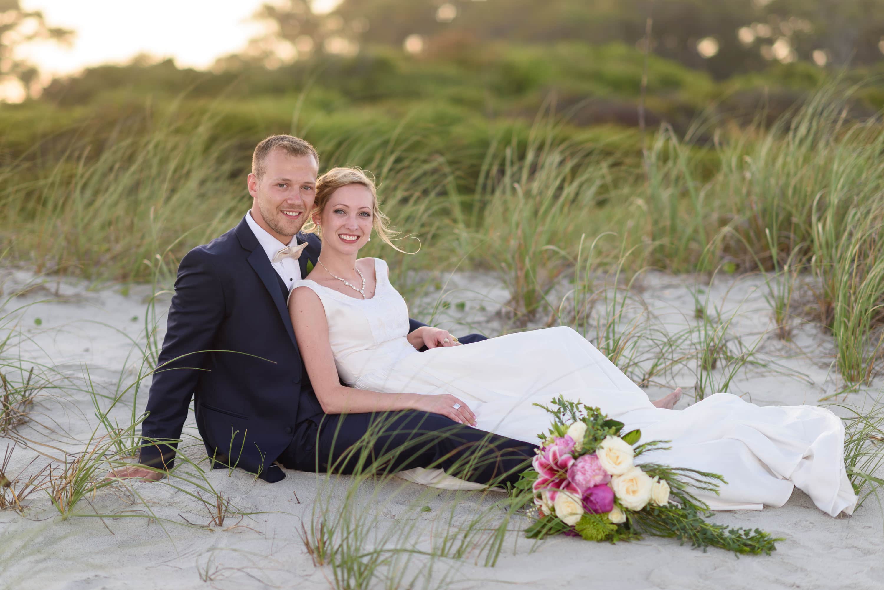 Couple laying together in front of the dunes -  Grande Dunes Ocean Club