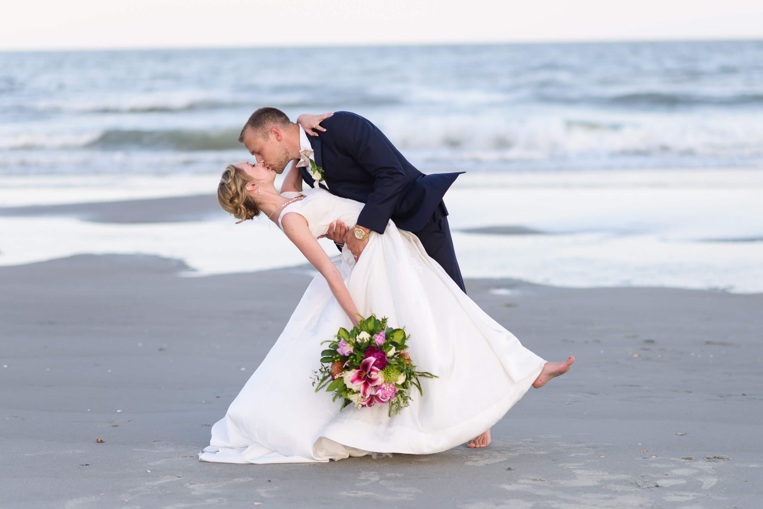Groom dipping bride back for a kiss -  Grande Dunes Ocean Club