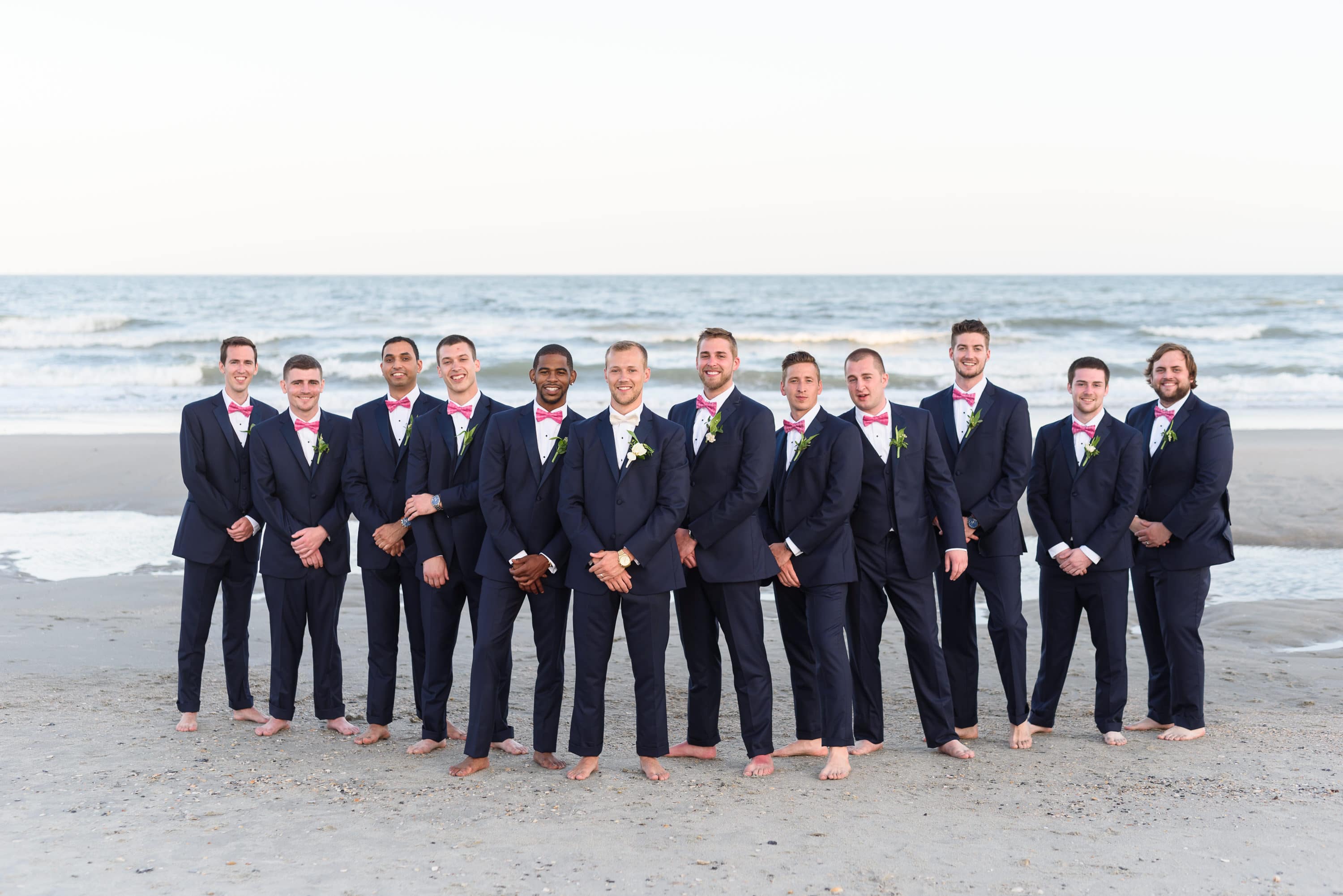 Groomsmen standing together in front of the ocean -  Grande Dunes Ocean Club