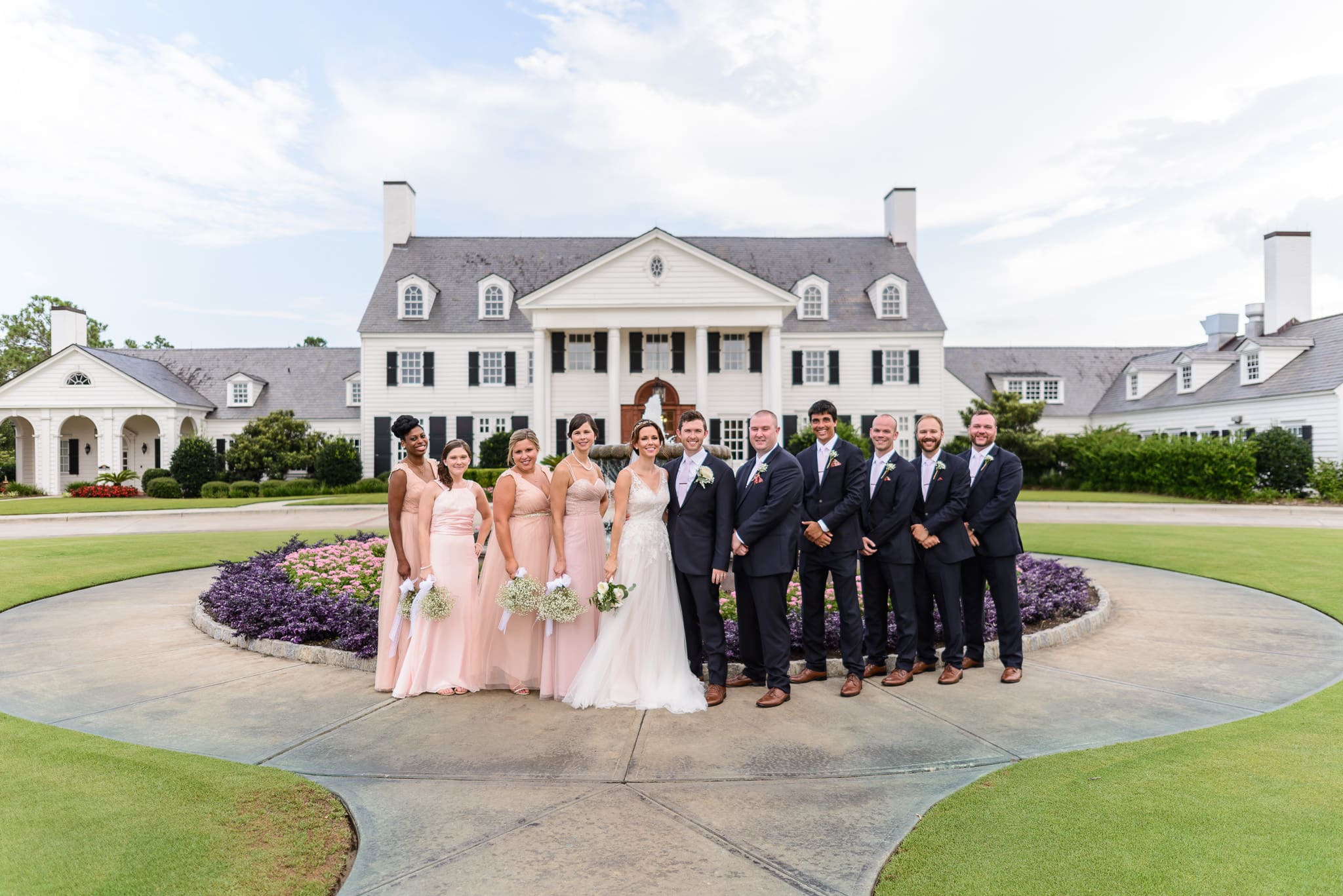 Bridal party standing in front of the fountain Pine Lakes Country Club