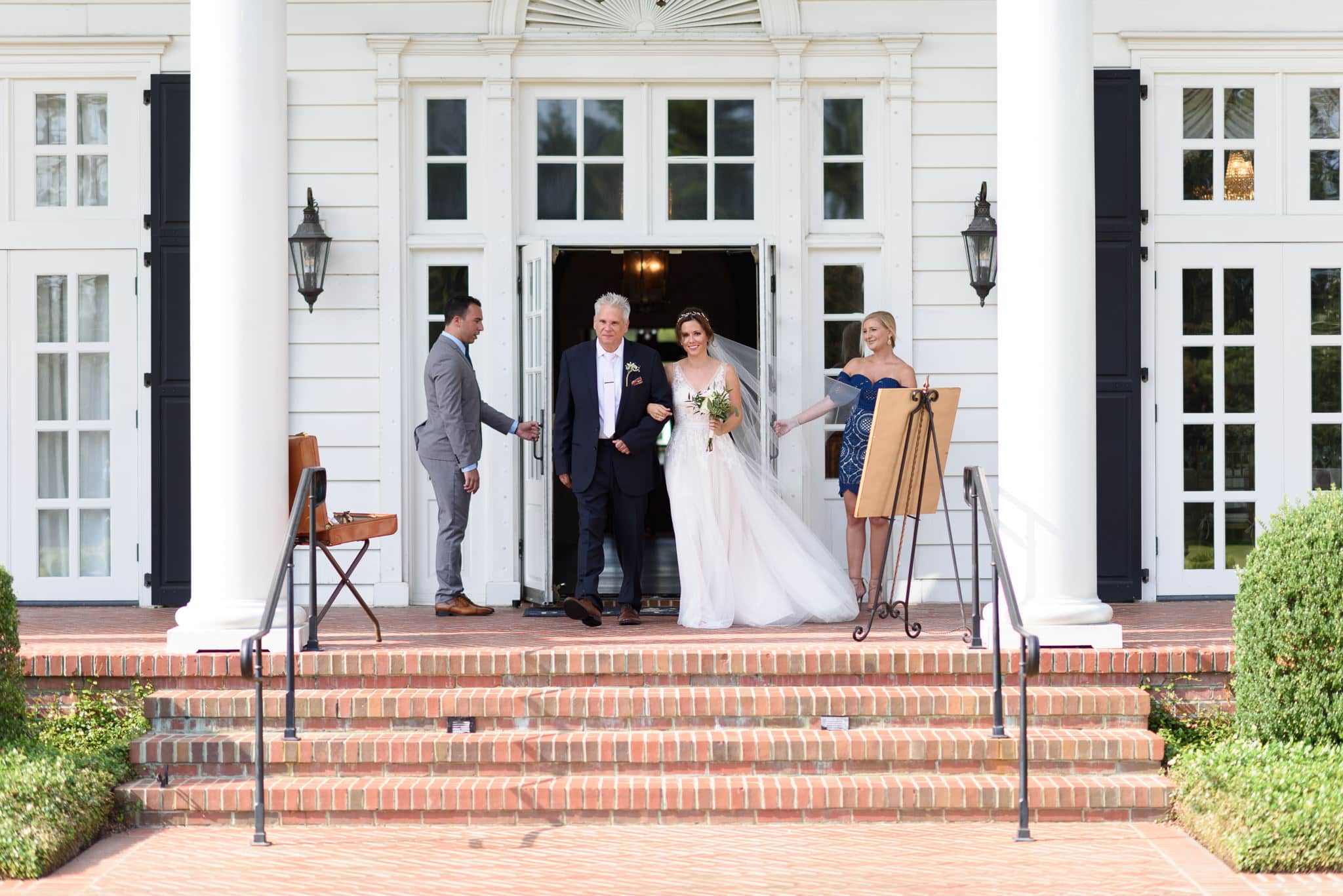 Bride and father walking out of doorway together Pine Lakes Country Club